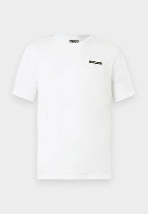 Biała bawełniana koszulka z krótkim rękawem, okrągłym dekoltem i małą czarną naszywką z logo na lewej piersi. Gładka faktura, standardowy krój.