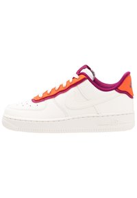 Sneaker bianco in pelle con vivaci accenti arancioni e viola. Presenta una punta tonda, perforazioni sulla zona della punta e una suola in gomma testurizzata.