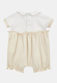 Mono corto de manga corta en blanco y beige con cuello tipo polo, dos broches en la parte posterior y cintura fruncida. Material de algodón suave con borde arrugado.