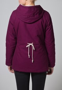 Giacca viola con cappuccio caratterizzata da una vita arricciata con un laccio crema, tessuto morbido e taglio casual, progettata per comfort e calore.
