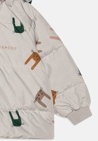 Kerge beež puffer-jakk pehme kangaga, millel on lõbusad kassi illustratsioonid rohelises, pruunis ja roosas. Elastsed mansetid ja logo detail olemas.