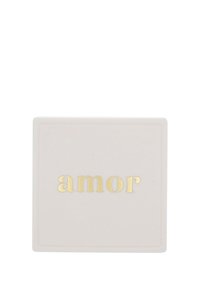 Kvadratisk keramikbox i matt vitt med en slät yta. Guldtext som stavar "amor" på framsidan. Enkel design, inga ytterligare mönster.