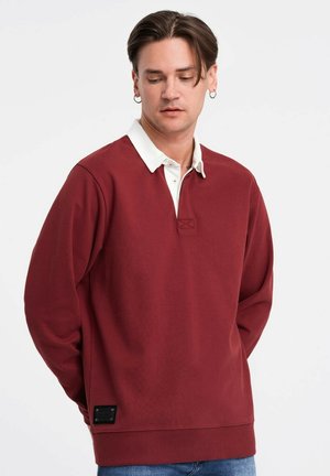 Bordeaux pullover sweatshirt med en hvid polo krave, lange ærmer og ribbede manchetter. Har et broderet logo og et struktureret materiale.
