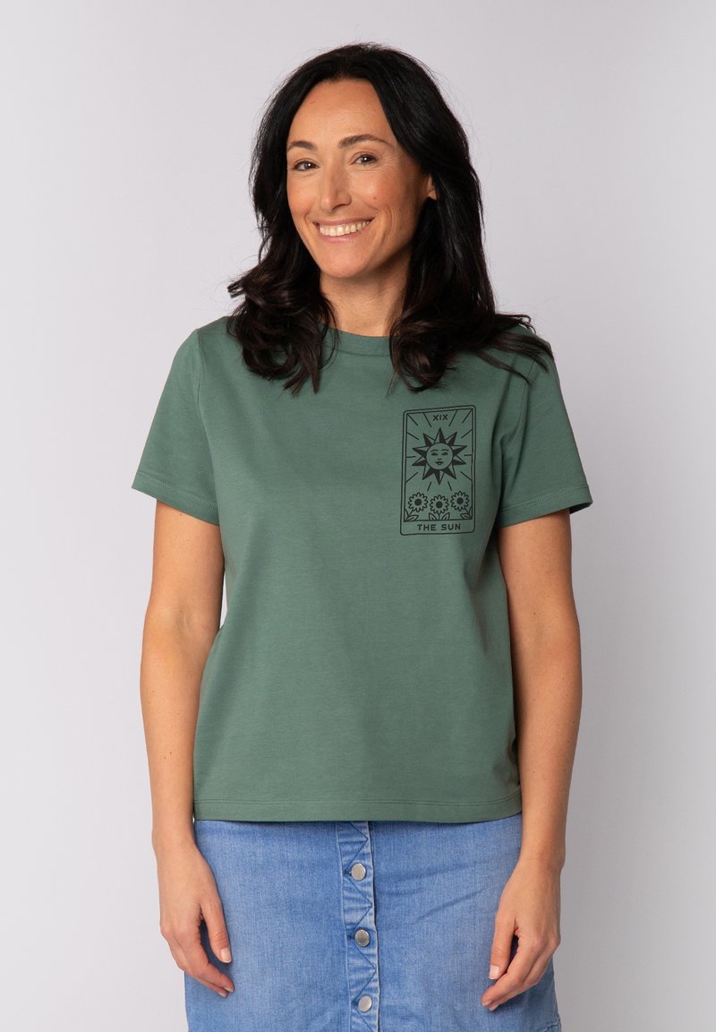 Groene katoenen t-shirt met korte mouwen, voorzien van een zwart gedrukt grafisch ontwerp van de zon en tarotkaart-elementen op de linkerborst. Rechte pasvorm.