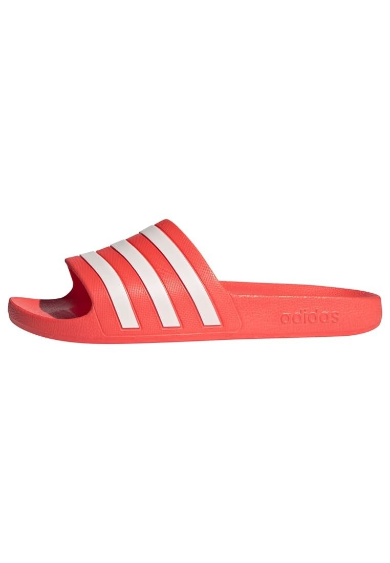 Adidas slide sandalen in fel koraal met drie witte strepen, voorzien van een textured strap en een gevormde voetbed voor comfort.