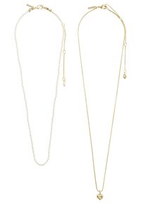 Deux colliers : une chaîne de perles blanches, texture lisse, et une chaîne en or avec un pendentif en forme de cœur et des détails fins. Les deux présentent des longueurs réglables.