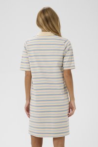 Polo kleit, mis on valmistatud pehmest kangast, sisaldab horisontaalriba kreemi, helesinise ja tumesinise värviga. Lühikesed varrukad ja klassikaline krae.