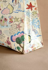 Musterhafte Tragetasche mit einem crèmefarbenen Hintergrund, der farbenfrohe Illustrationen von Wolken, Sternen, Meereslebewesen und Flora zeigt, hergestellt aus strapazierfähigem Stoff.