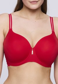 Reggiseno rosso imbottito con spalline doppie regolabili, scollatura a V e un piccolo dettaglio con cerniera dorata al centro davanti. Texture liscia.