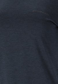 Marinblå idrottströja i lättviktigt tyg, med en mjuk textur och subtilt "ENDURANCE"-logotyp i kontrasterande material.