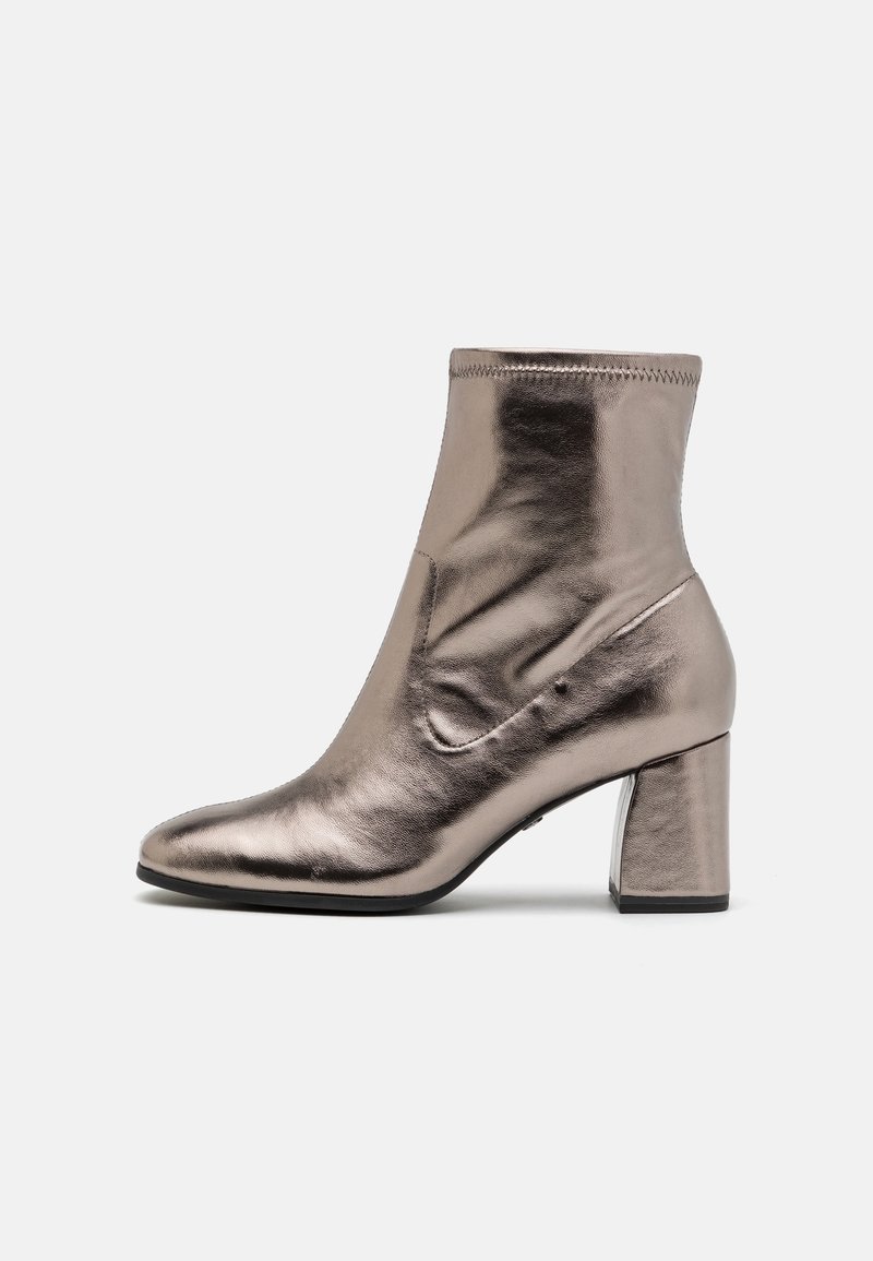 Bottine argentée métallique avec un bout carré arrondi, une texture en cuir lisse et un talon bloc sur un fond gris clair uni.
