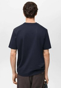 Navy blue cotton t-shirt, short sleeves, crew neck, relaxed fit, smooth texture, with a subtle brand tag at the lower left side.