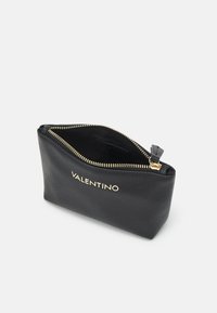 Pochette en cuir noir avec une surface texturée, fermeture éclair dorée et logo "VALENTINO" à l'avant. Le dessus ouvert révèle un intérieur noir.