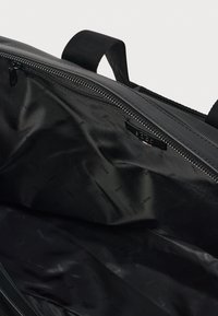 Εσωτερικό μαύρης υφασμάτινης τσάντας με λεία υφή, διαθέτοντας φερμουάρ και εσωτερική επένδυση με επαναλαμβανόμενο λογότυπο «BOSS».