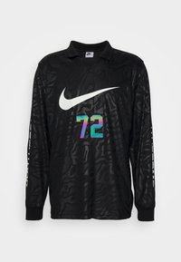 Maillot de sport Nike à manches longues, noir, avec un motif sombre subtil, un grand logo swoosh blanc et un numéro 72 coloré sur le devant.