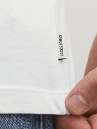 Hvid bomulds t-shirt med lige kant, der har et lille JACKET&JONES mærke syet på siden. Tekstureret stof, afslappet design.