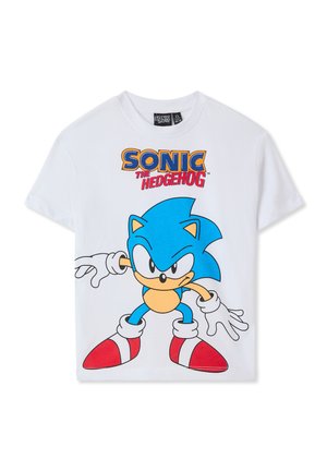 T-shirt bianco in cotone con una grande grafica blu di Sonic the Hedgehog, scarpe rosse e testo in grassetto che recita "SONIC THE HEDGEHOG."