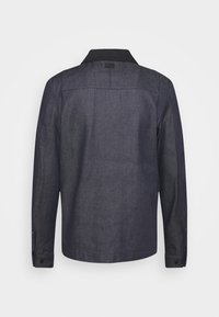 Dark denim jacket with a black collar, long sleeves, and button cuffs. Features a straight cut and visible stitching on the back.