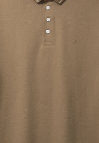 Polo marron texturé avec trois boutons blancs et petit détail brodé en forme de "X" sur la poitrine.