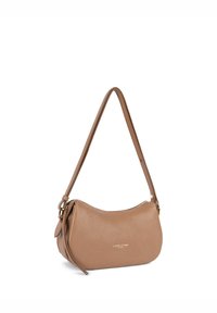 Sac à main en cuir fauve à forme incurvée, avec une bandoulière réglable et un logo doré. Il comporte une fermeture éclair et un détail de pompon latéral.