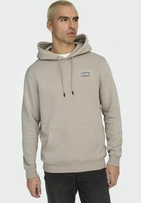 Hoodie beige chiaro realizzato in misto cotone, con tasca frontale, cappuccio con coulisse e un piccolo logo stampato sul petto.