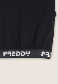 Top corto nero realizzato in tessuto morbido. Presenta un orlo arricciato e una larga banda elastica con il logo "FREDDY" in bianco.
