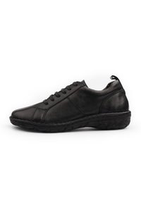 Black leather sneaker with a smooth finish, rounded toe, lace-up design, and rubber sole featuring textured detailing.