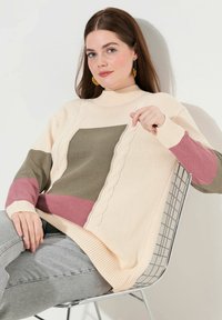 Sweter dzianinowy z golfem, z segmentami w kolorze beżowym, oliwkowym i mauve. Teksturowane detale wzdłuż szwów, luźny fason.