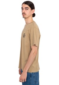 Beige cotton t-shirt with short sleeves, crew neck, and a logo printed on the chest. Features a relaxed fit and straight hem.