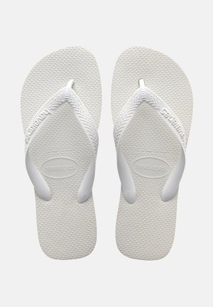 Bílé gumové žabky s texturovanou podešví a širokými popruhy. Název značky "Havaianas" vyražený na popruhu. Lehký design.