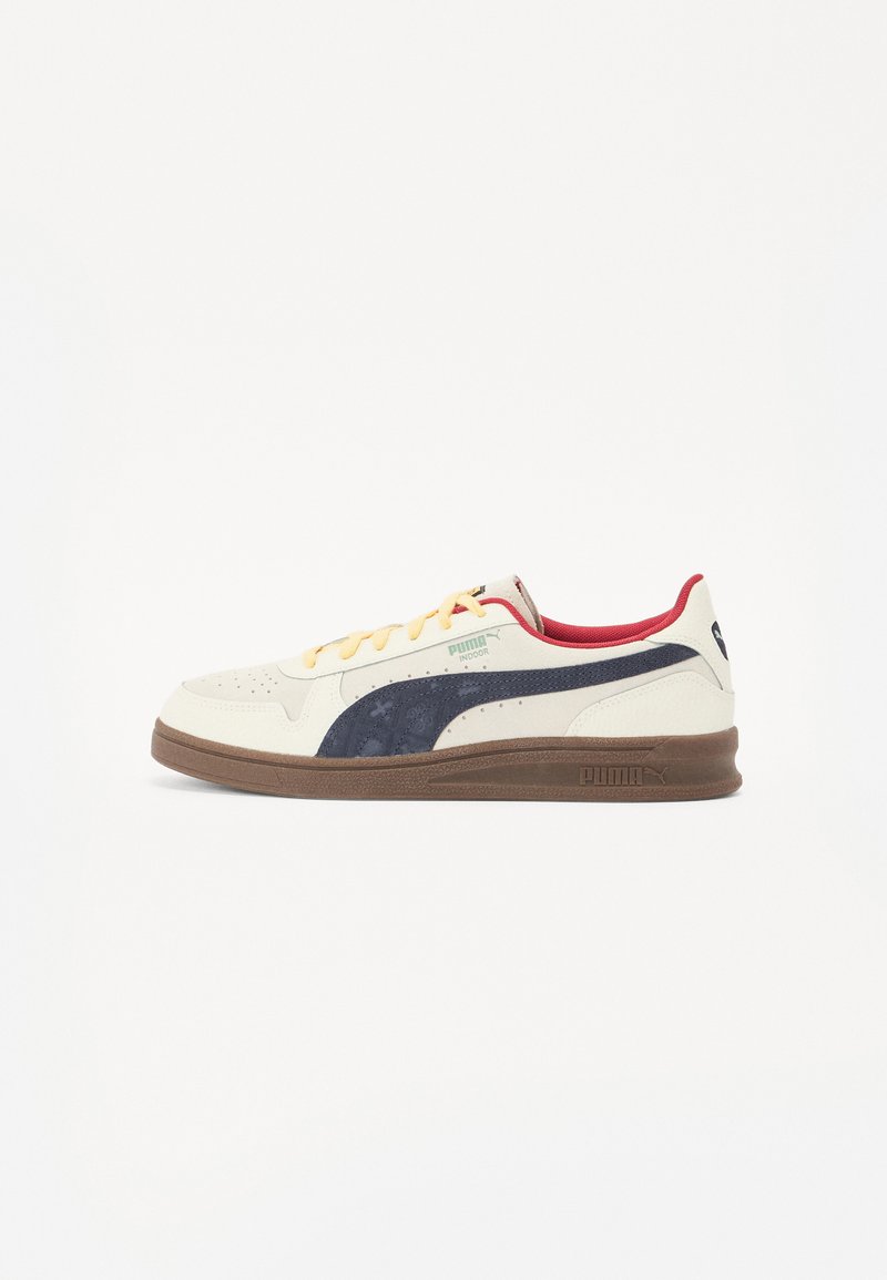 PUMA sneakers i cremefarvet læder med marineblå accenter, featuring gule snørebånd og en rød krave. Mørkebrun gummisål med logodetalje.