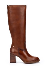 Botte pour femme en cuir marron, haute, avec un talon bloc et des coutures décoratives près de la cheville, finition lisse et une languette en haut.