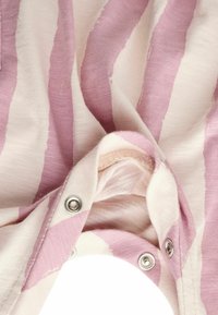 Stribet stof i blød pink og creme, der har en let tekstur med sølv snapknapper, hvilket skaber et afslappet design.