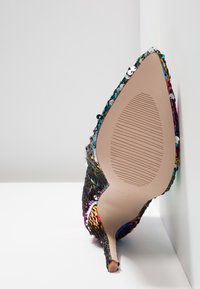 Hakken met een spitse neus, bedekt met kleurrijke pailletten en metalen draden. De zool is glad met een textuurpatroon voor grip.