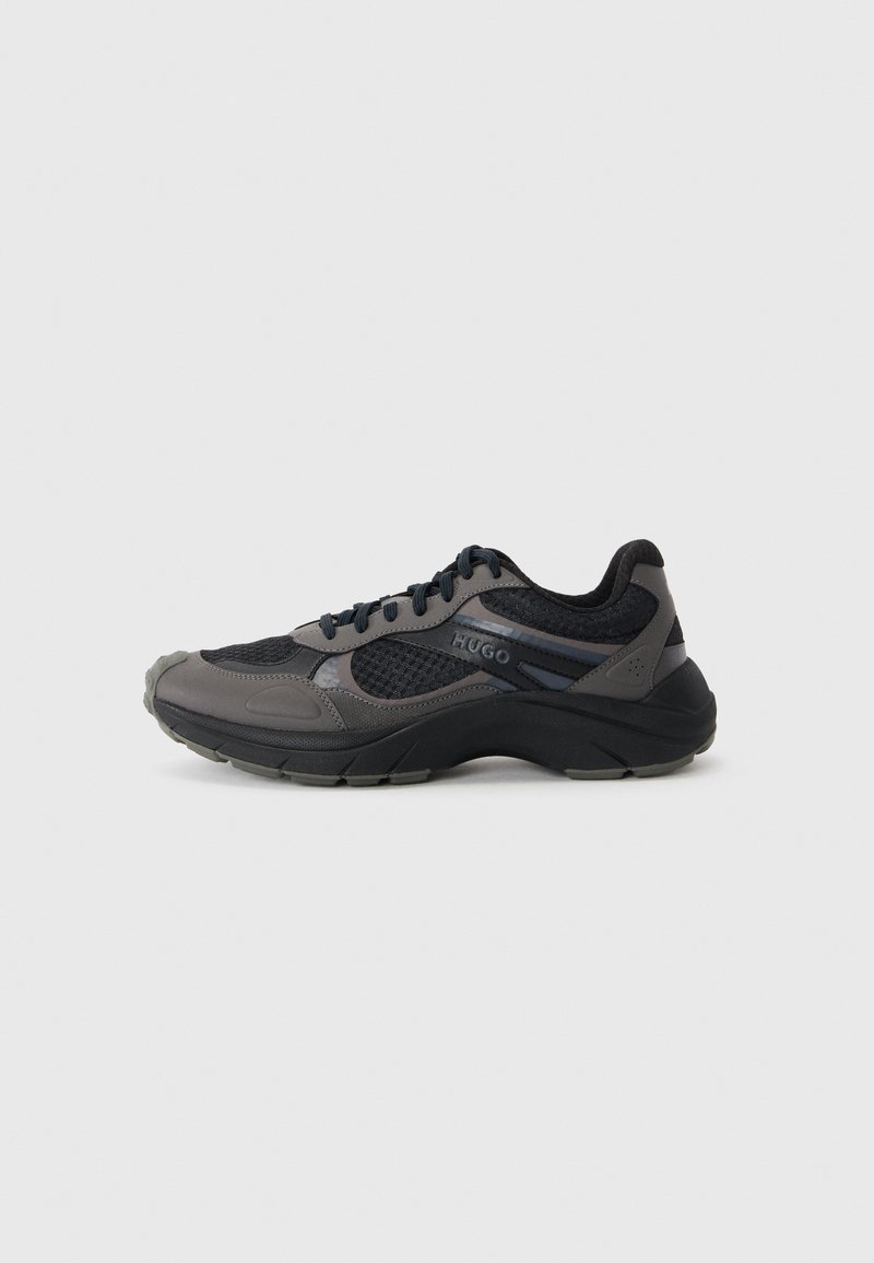 Sport sneakers in black and grey with a breathable mesh upper, padded collar, and textured rubber sole. Features branding on the side.