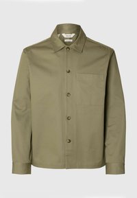 Chemise à manches longues vert olive avec col pointu, boutons à l'avant et une poche poitrine sur un fond clair uni.