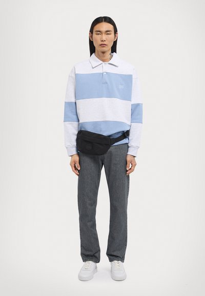 Herre langermet polo i lys grå med blå striper, kombinert med mørkegrå jeans og en svart bumbag, fullført med hvite joggesko.