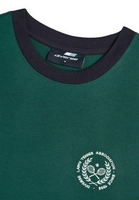 Ciemnozielona koszulka z granatowym okrągłym dekoltem, z białym haftowanym logo 'Lawn Tennis Association' i rakietami tenisowymi w laurze.