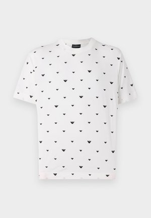 T-shirt de manga curta branca com um padrão em forma de V repetido em preto, feita de algodão macio, com um corte descontraído e decote redondo.