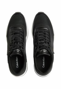 Sneakers neri con tomaia in tessuto texture, dettagli a motivo, lacci piatti e suola in gomma bianca. Logo stampato sulla soletta.