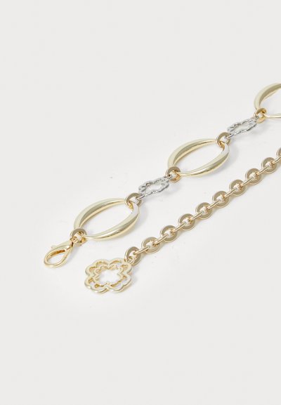 Bracciale in catena di link oro e argento con grandi elementi a forma circolare e floreale, dotato di chiusura a moschettone e finitura lucida.