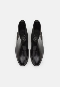 Botine negre până la gleznă, cu un finisaj din piele lucioasă, panouri elastice pe laterale și презгuri; prezintă un vârf rotunjit și o talpă texturată.