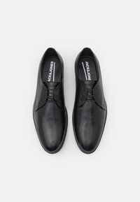 Schwarze Lederschuhe mit glatter Oberfläche, runder Zehenform und minimalistischem Design. Mit Schnürsenkeln und einer markierten Innensohle.