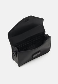 Borsa a mano in pelle nera con patta pieghevole, tasca interna con zip e logo. Texture liscia e forma strutturata per un aspetto elegante.