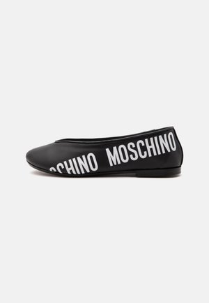 Chaussure plate noire avec un bout arrondi et texte blanc MOSCHINO imprimé en diagonale sur le côté.