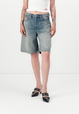 Shorts di jeans di colore azzurro chiaro con una finitura sbiadita, cinque tasche e chiusura con bottone. Abbinati a mules neri con punta a punta e con cinturini.