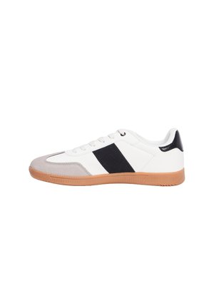 Sneaker blanc avec des accents gris et noirs, dotée d'une semelle en gomme texturée et d'un dessus en cuir lisse. Lacets et coque de protection renforcée.