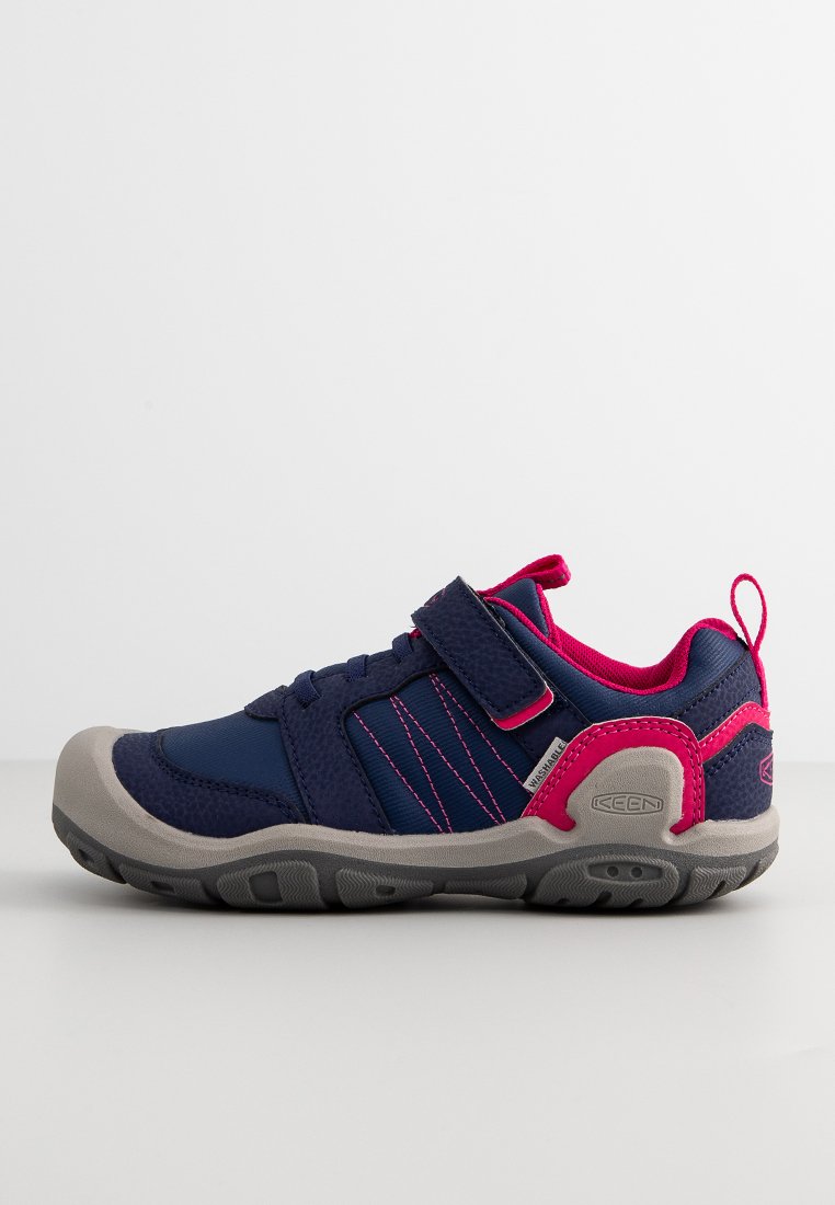 Zapatilla infantil en azul marino y rosa con suela gris, cinta de velcro, materiales de malla y sintéticos, y tirador en el talón.