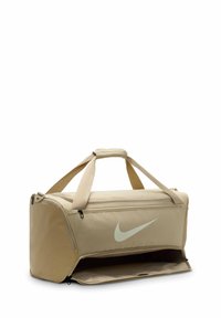 Beige sporttas gemaakt van duurzaam materiaal, met een groot ritscompartiment, twee handvaten en een opvallend lichtgroen Nike-logo.