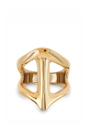 Anillo de tono dorado con forma de casco estilizado de caballero medieval, con aberturas para los ojos y superficie lisa y pulida.